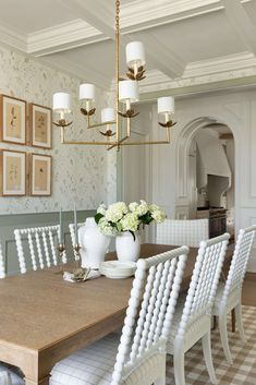 a dining room table with white chairs around it