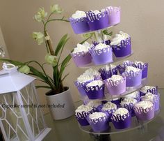 cupcakes are stacked on top of each other in purple and white frosting