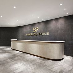 the front desk of samsung prime in an empty office space with black walls and flooring