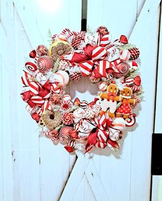 a christmas wreath made out of candy canes and candies on a white door