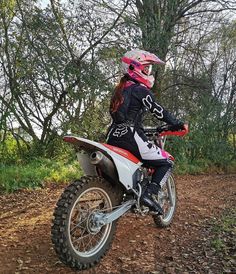 a woman riding on the back of a dirt bike