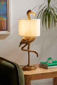 a lamp that is sitting on top of a table next to a chair and a potted plant