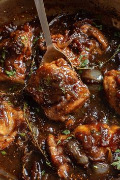 a pot filled with meat covered in sauce and garnished with parsley