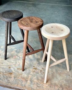 three stools sitting on top of a cement floor