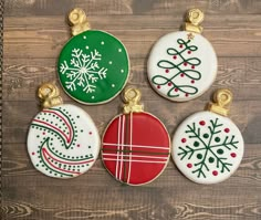 four decorated christmas ornament ornaments on a wooden surface