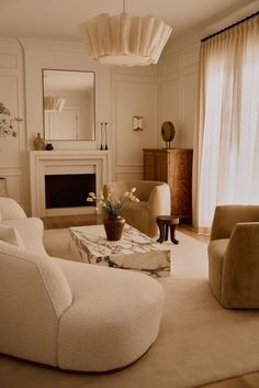 a living room filled with furniture and a fire place next to a mirror on the wall