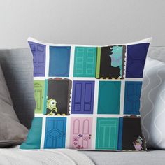 a throw pillow with monsters on the front and side doors in different colors, including blue, green, pink, purple, yellow