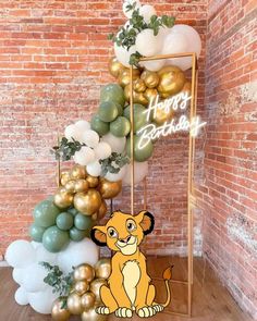 the lion king balloon arch is decorated with gold, white and green balloons