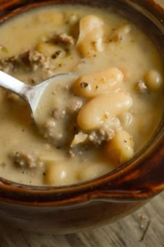 a wooden bowl filled with soup on top of a table