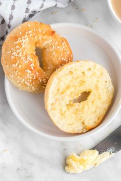 two sesame bagels on a plate with butter