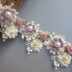 some flowers and pearls are attached to a piece of lace