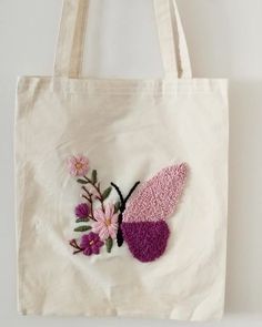 a white bag with pink flowers and a butterfly on it