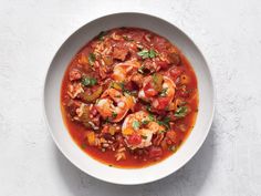 a white bowl filled with shrimp and tomato soup