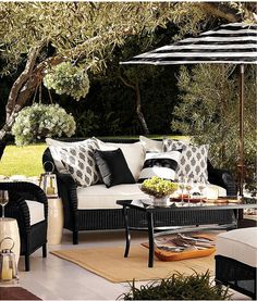 an outdoor living room with black and white furniture