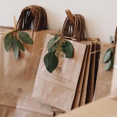 brown paper bags with green leaves tied to them hanging on a wall in a store