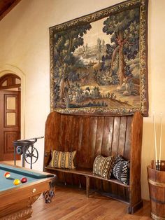 a pool table in a room with a tapestry on the wall