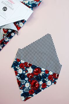 two pieces of fabric are laying on top of each other, one is blue and the other has red flowers