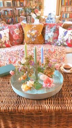 a wicker coffee table with candles and flowers on it