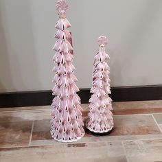 two pink vases sitting on top of a tiled floor