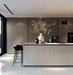 a modern kitchen with an island and bar stools next to the countertop area