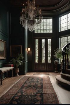 an ornate entryway with chandelier and stairs