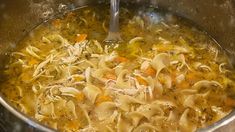 a pot filled with soup and noodles on top of a stove