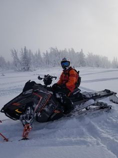 a man riding on the back of a snowmobile