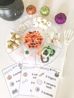 a table topped with lots of different types of halloween foods and candy bars on top of it