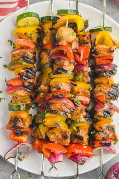 chicken kabobs with peppers and onions on a white plate