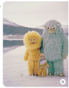 three stuffed animals standing next to each other in the snow