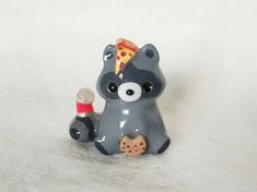 a small toy bear with a slice of pizza on its head