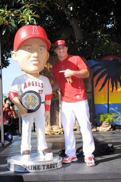 a man standing next to a statue of a baseball player