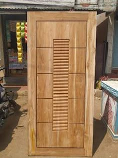 a wooden door sitting on the side of a road