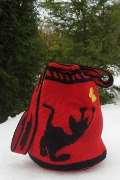 a red bag sitting on top of snow covered ground