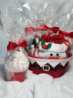 a basket filled with christmas items on top of a white table cloth covered bedding