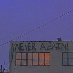 an old building with graffiti written on it's side and the sky in the background