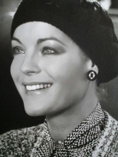 a black and white photo of a woman wearing a tiara smiling at the camera