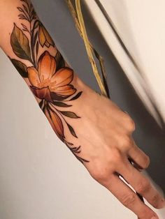 a person's hand with flowers on it and the words tattoos tattooed above them