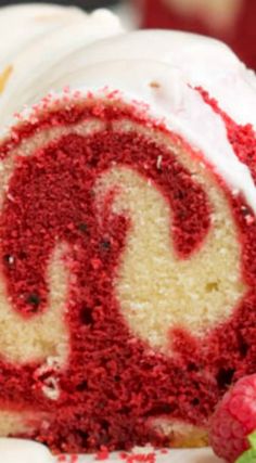 a red and white swirl cake with raspberries on the side