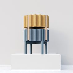 a blue chair sitting on top of a white pedestal