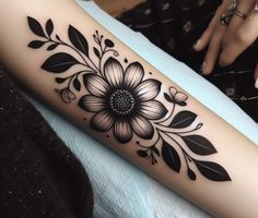 a woman's arm with a flower tattoo design on the left side of her leg