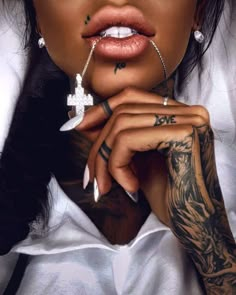 a woman with tattoos and piercings on her face