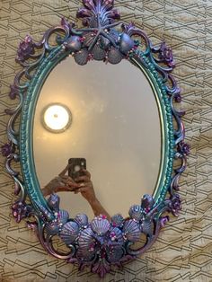 a person taking a selfie in front of a round mirror with flowers on it