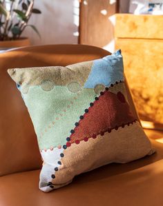 a pillow sitting on top of a brown chair