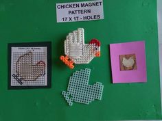 cross stitch chicken magnets are displayed on a bulletin board with other crafting items