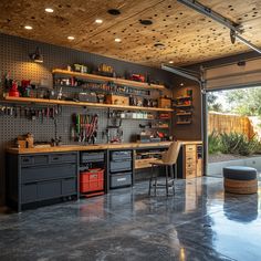 a garage with lots of tools on the wall and shelves full of work equipment in it