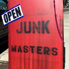 a red sign that says junk masters on it with a chain hanging from the front