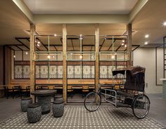 an old fashioned horse drawn carriage is in the middle of a room with tables and benches