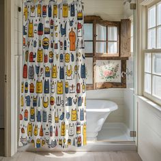 a bathroom with a shower curtain that has cats on it and other things in the bathtub