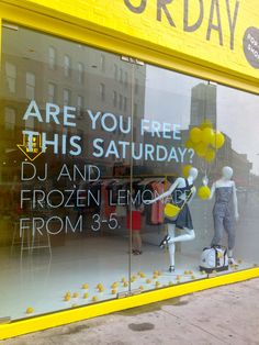 a storefront window with mannequins and balloons in the window, which says are you free this saturday?